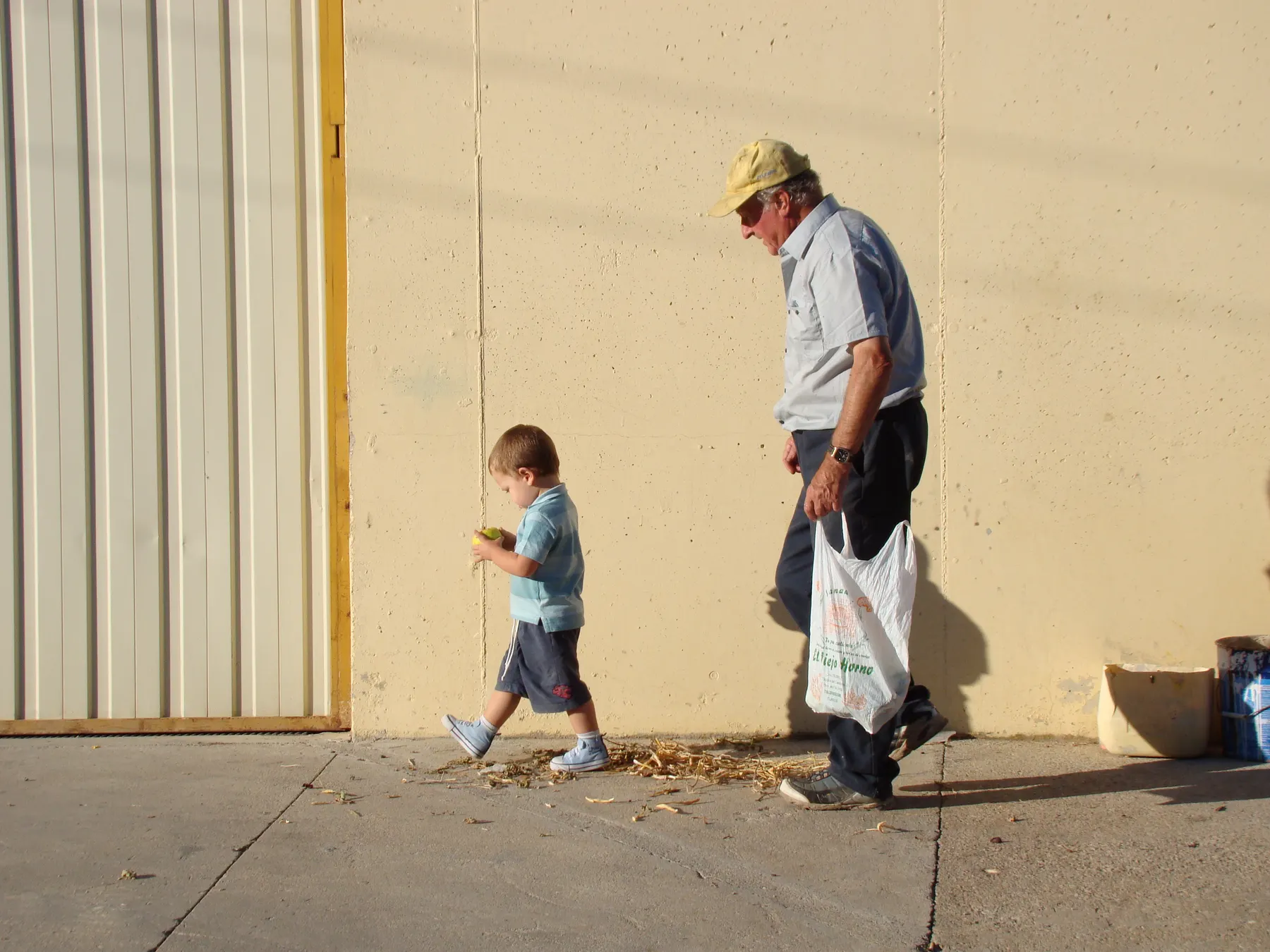 Abuelo y nieto paseando juntos a la luz dorada de la tarde