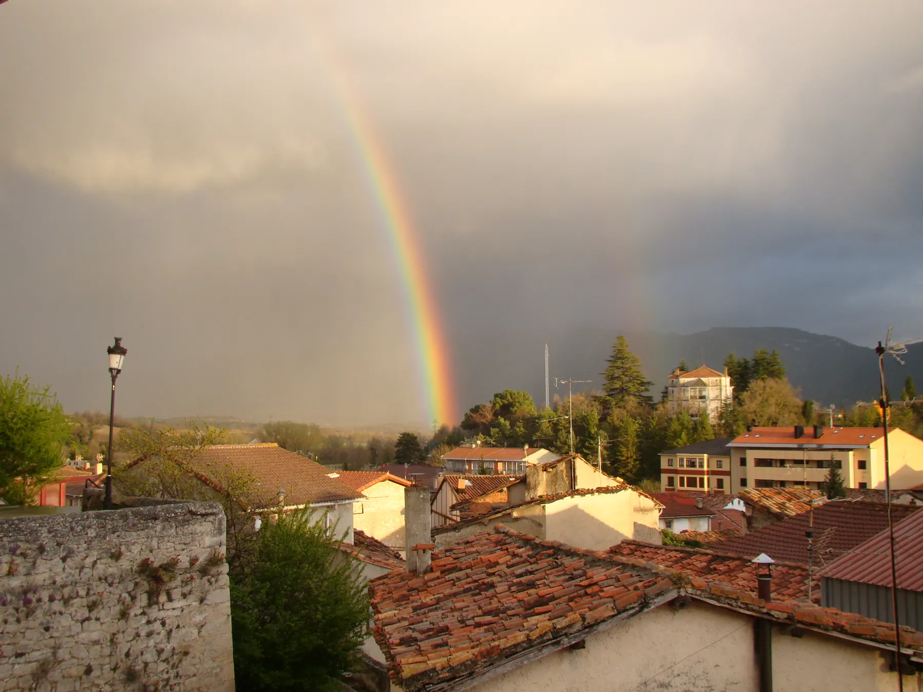 Arcoíris sobre los tejados del pueblo tras la lluvia